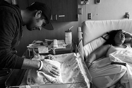 عکس مستند از پدری که در بیمارستان به نوزاد خود نگاه