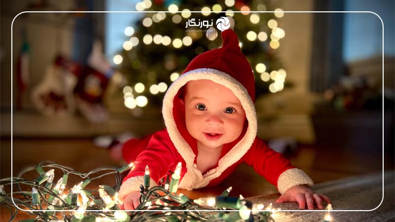 بازی کودک با چراغ‌های کریسمس