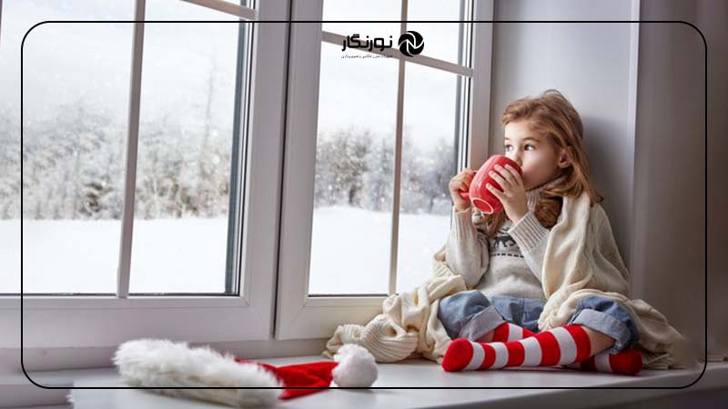 نگاه کودک به پنجره برفی