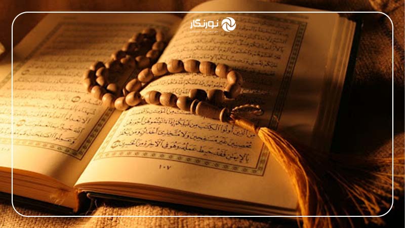 عکس از یک قرآن باز با نور ملایم و تاریکی اطراف