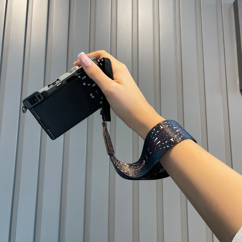 مشخصات + بهترین قیمت برای خرید بند دوربین مچی طرح چشمی تیره Bandino Wrist camera strap dark eyes | مشاوره تخصصی 0217356